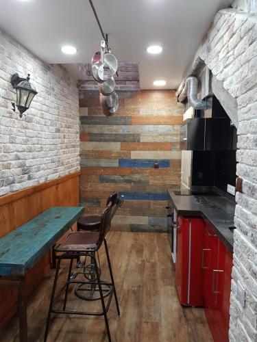 a kitchen with a table and a brick wall at Tiny apartment on the roof touching Gibraltar in La Línea de la Concepción