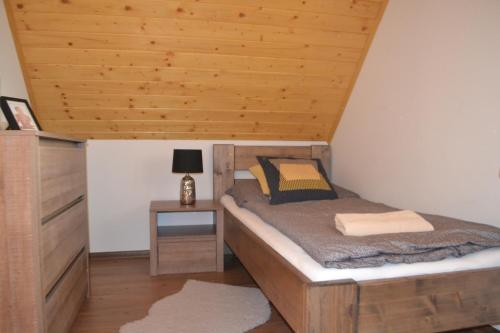 Un dormitorio con una cama y un techo de madera. en Villa Manatt, en Stará Lesná