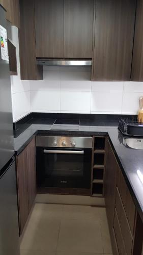 Una cocina con horno negro y gabinetes de madera. en Departamento Central Uno Norte Viña del Mar, en Viña del Mar