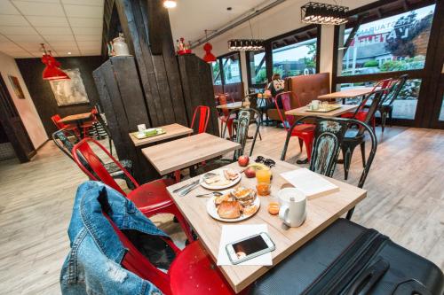 a restaurant with tables and chairs and people sitting at tables at ibis Styles Chartres Métropole in Chartres
