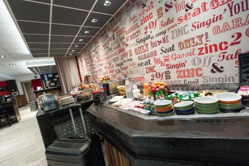 a restaurant with a counter with food on it at ibis Styles Chartres Métropole in Chartres