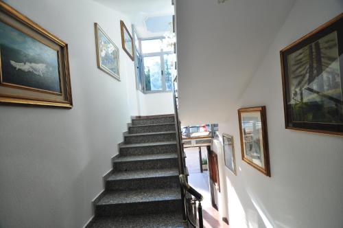 a stairway with paintings on the wall and a stair case at Aparthotel Shkodra in Durrës