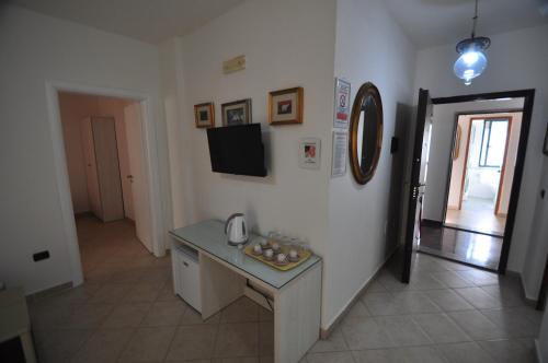 a room with a table and a television on a wall at Aparthotel Shkodra in Durrës