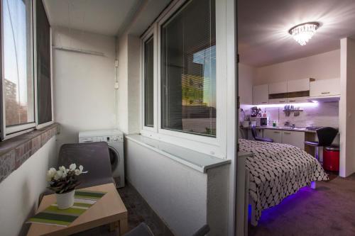 Cette petite chambre comprend un lit et une fenêtre. dans l'établissement Studio Apartment Petrzalka Air-Conditioned 24h check-in, à Bratislava