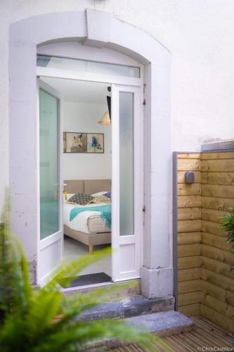 une porte ouverte sur une chambre avec un lit dans l'établissement Résidence le XV, à Bagnères-de-Bigorre