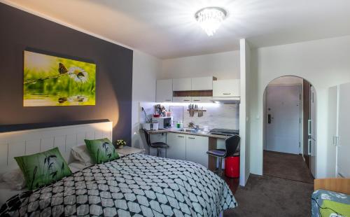 Un pequeño dormitorio con una cama y una cocina. en Studio Apartment Petrzalka Air-Conditioned 24h check-in, en Bratislava