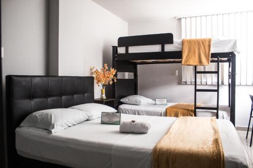 2 Betten in einem Zimmer mit Etagenbett in der Unterkunft Hotel Escorial Ibague in Ibagué