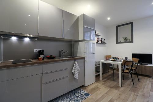 cocina con electrodomésticos de acero inoxidable y mesa en Cosy appartement Bayonne historique, en Bayona