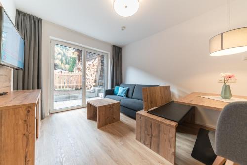 un salon avec un canapé et une table dans l'établissement Hochstatt Appartements, à Sölden
