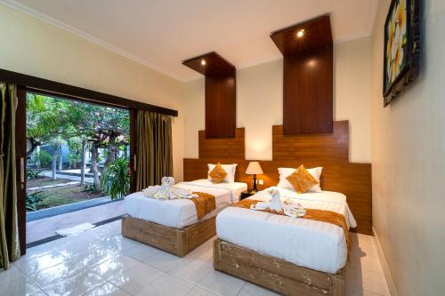 a bedroom with two beds and a large window at Pondok Jenggala in Nusa Lembongan