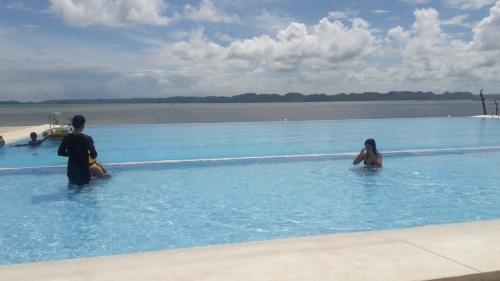 a couple of people in a swimming pool in the water at Sea Garden Resort Iloilo in Iloilo City