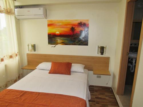 a bedroom with a bed and a painting on the wall at Hosteria B y B in Tonsupa