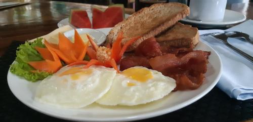 a plate of food with eggs and bread and vegetables at Kim's Garden in Anda