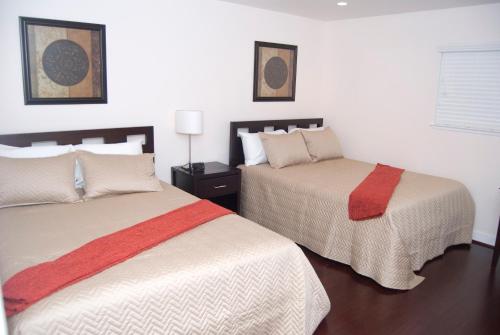 two beds in a room with white walls at Silicon Valley Stays Casa Tres in Mountain View