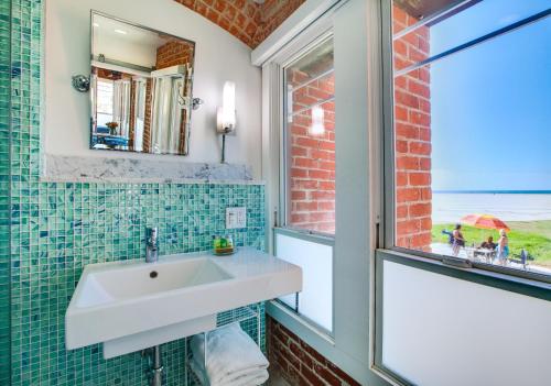 a bathroom with a white sink and a window at Venice Breeze Suites in Los Angeles