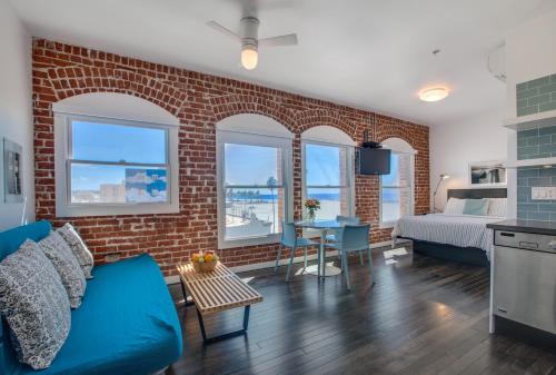 a living room with a blue couch and a brick wall at Venice Breeze Suites in Los Angeles