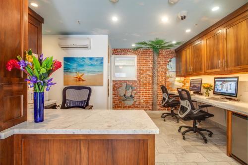 a kitchen with chairs and a counter with a vase of flowers at Venice Breeze Suites in Los Angeles