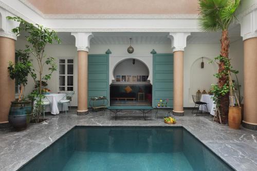 una piscina nel mezzo di una stanza con una casa di Riad Albatoul a Marrakech