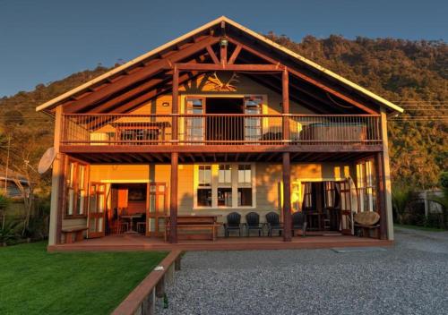 a large wooden house with a large deck at The Ghost Lodge in Granity