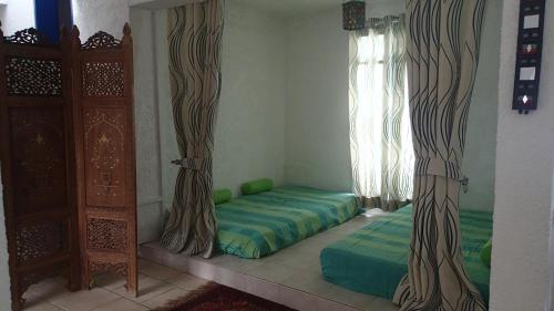 a room with a bed and a window with curtains at Villa Talassa in Le Morne
