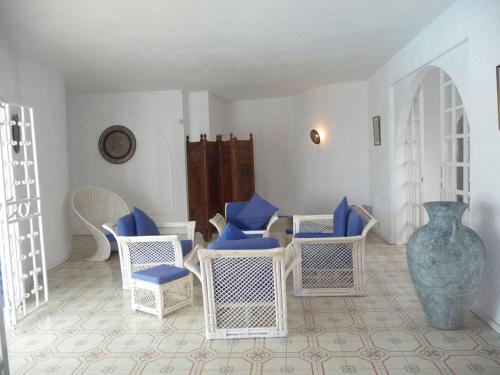 a room with chairs and a table and a vase at Villa Talassa in Le Morne