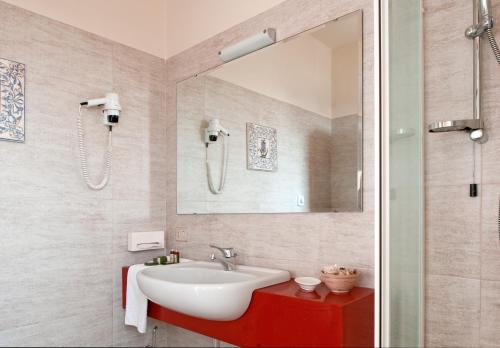a bathroom with a sink and a mirror at Hotel Ambasciatori in Brescia