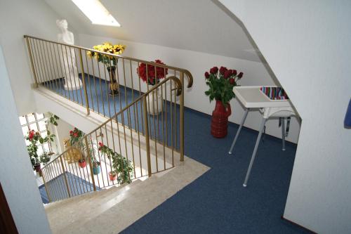 a hallway with stairs with flowers and a table at Hotel Dorfkrug Büsum in Büsum