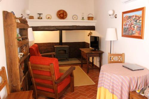 a living room with a table and a chair and a stove at Estalagem de Marvão in Marvão