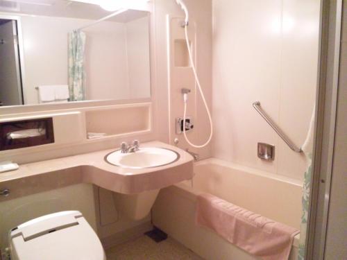 a bathroom with a sink and a toilet and a shower at Onomichi View Hotel Seizan in Onomichi