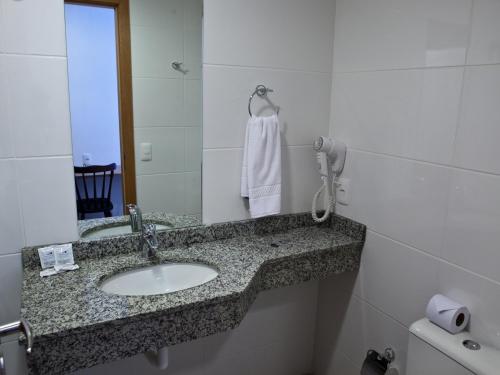 y baño con lavabo y espejo. en Al Mare Hotel, en Florianópolis