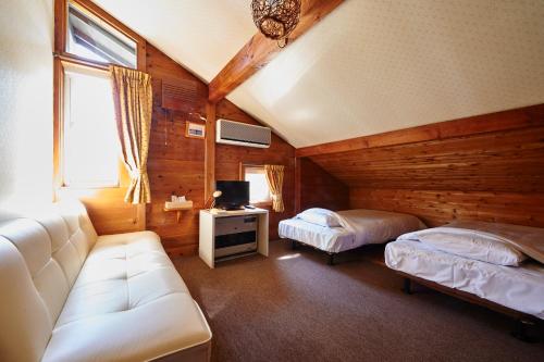 salon z 2 łóżkami i kanapą w obiekcie Lake village donaludo Pension w mieście Kitashiobara