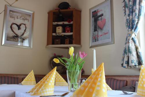 a table with a vase of flowers on it at Mohnhotel - Bergwirt Schrammel in Zwettl Stadt