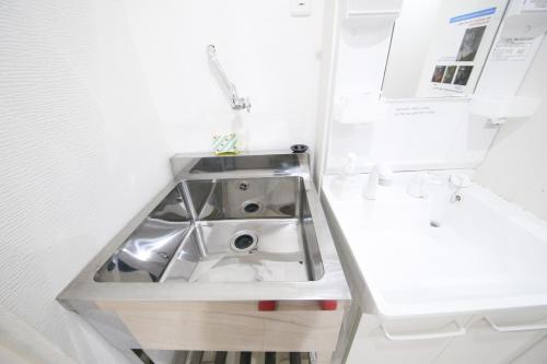 uma casa de banho com um lavatório e um lavatório em Guest House Re-worth Yabacho1 402 em Nagoia
