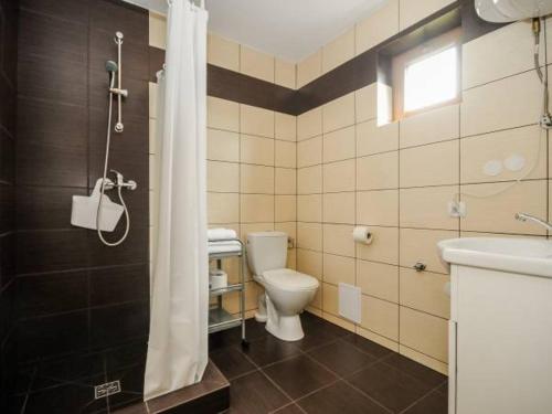 a bathroom with a shower and a toilet and a sink at Agromarko in Ustronie Morskie