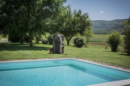 a swimming pool in front of a field with trees at Monteriggioni Suite in Monteriggioni