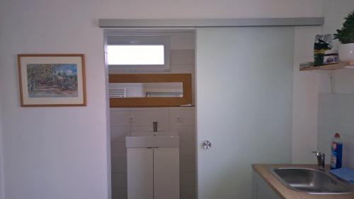 a small kitchen with a sink and a window at Ferienwohnung Schau ins Dorf in Ostercappeln