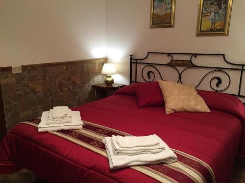 a bedroom with a red bed with towels on it at Etna View Affittacamere in Giardini Naxos