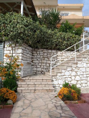 a stone retaining wall with stairs in front of a house at Guesthouse Villa Joanna&Mattheo in Sarandë