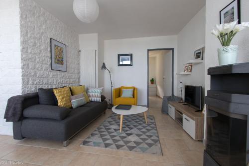 a living room with a couch and a tv at L'Eternel Estivant in Sète