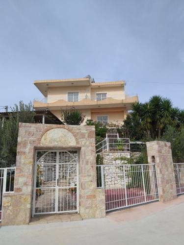 a building with a gate in front of a house at Guesthouse Villa Joanna&Mattheo in Sarandë