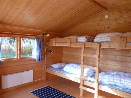 a bedroom with bunk beds in a log cabin at 4 persoons Stuga in Hammarstrand