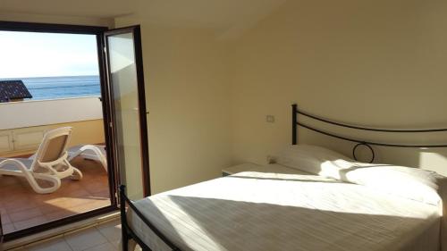 a bedroom with a bed and a view of the ocean at Il Borgo della Marinella Case Vacanze in Amantea