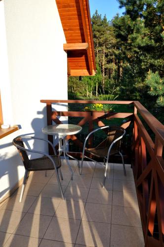 a patio with a table and chairs on a balcony at Gościniec Kaszubski Homestay in Białogóra
