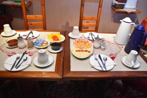a table with plates of food and utensils on it at Penzion Na Kopečku in České Budějovice
