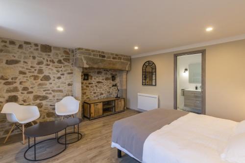 um quarto com uma cama grande e uma parede de pedra em Chambre d'hôtes La Longère em Sotteville