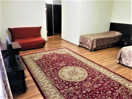 a living room with a red rug and a couch at Sultan Beibarys in Astana