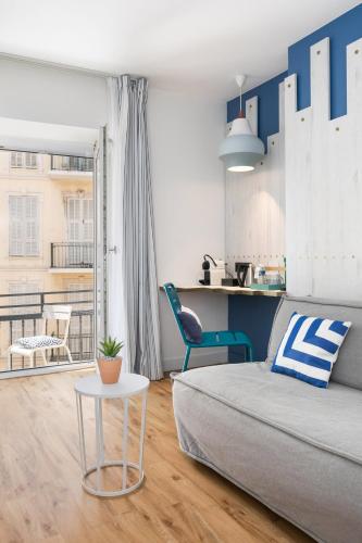 una sala de estar con una cama y una mesa en The Deck Hotel by Happyculture, en Niza