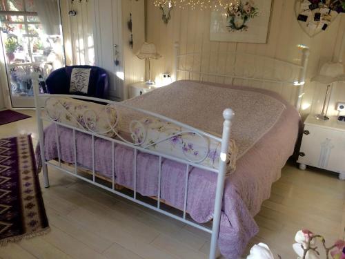 1 dormitorio con 1 cama blanca con sábanas moradas en B&B Het Tuinhuisje, en Enschede