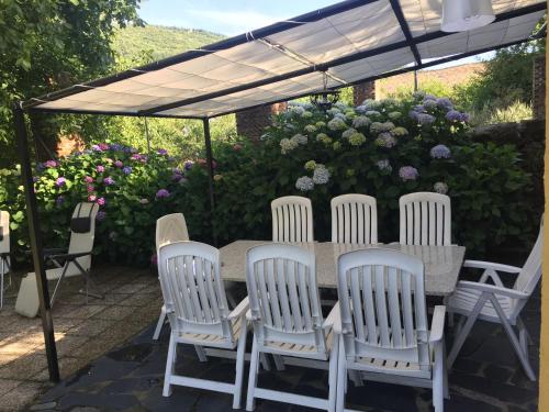 a table and chairs under a canopy with flowers at Casa Camino Real in Puerto de Béjar