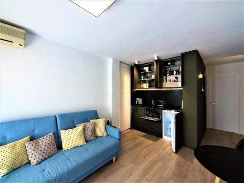 Il comprend un salon avec un canapé bleu et une cuisine. dans l'établissement Rambla Suite Estudio, à Alicante